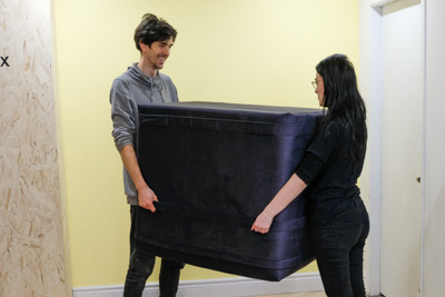 Deux personnes tiennent le cube dans les airs avec la sangle du milieu.