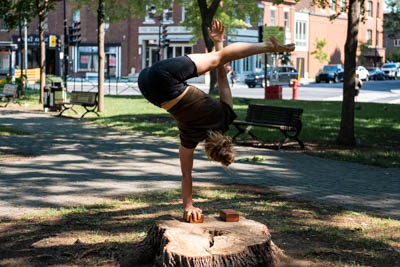 Artiste de cirque faisant un équilibre à une main sur un bloc.