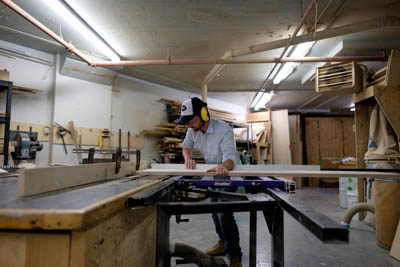 Adrien making cuts on the table saw.