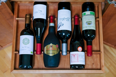 A top view of a drawer with 6 bottles head to tail.
